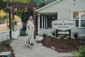A sign for Swank Suites with a clear address and a well-maintained outdoor area with a pergola and string lights. - Swank Boutique Suites | King Suite | DT Ashland (Ashland)