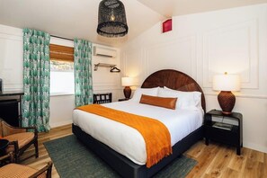 A hotel room with a large bed, two bedside tables, a desk, and a chair.