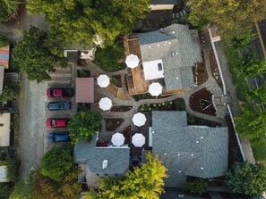 An aerial view of a residential area with multiple houses, a driveway, and a parking area.