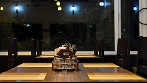 Un restaurante con una larga mesa de madera, sillas y un centro decorativo.