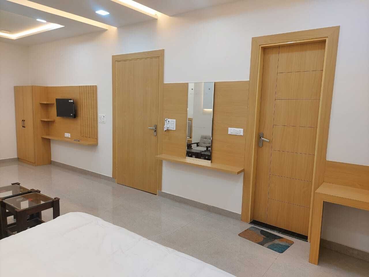 Una habitación de hotel con cama, escritorio, silla y armario con espejo.