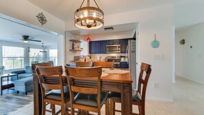 A spacious living room with a large sofa and a dining area with wooden chairs and a table. - Family Friendly! Games! Waterfront North Port Home (North Port)
