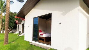 Ein Einzelzimmer mit Schiebetür, einem Bett und einem kleinen Fenster.