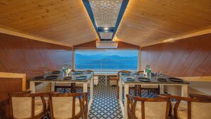 Un espace repas aux murs en bois, offrant une vue sur les montagnes grâce à une grande fenêtre.
