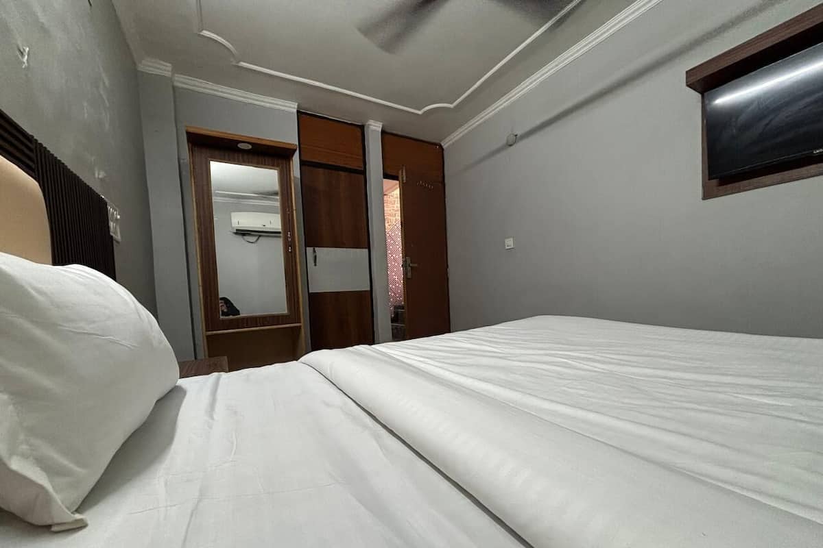 A bedroom with a bed, a wardrobe, and a mirror.
