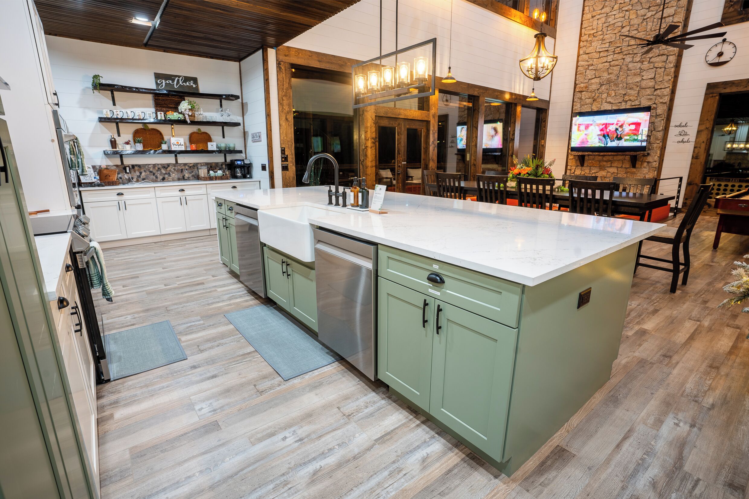 Una cocina moderna con una isla grande, electrodomésticos integrados y una pared de piedra rústica.
