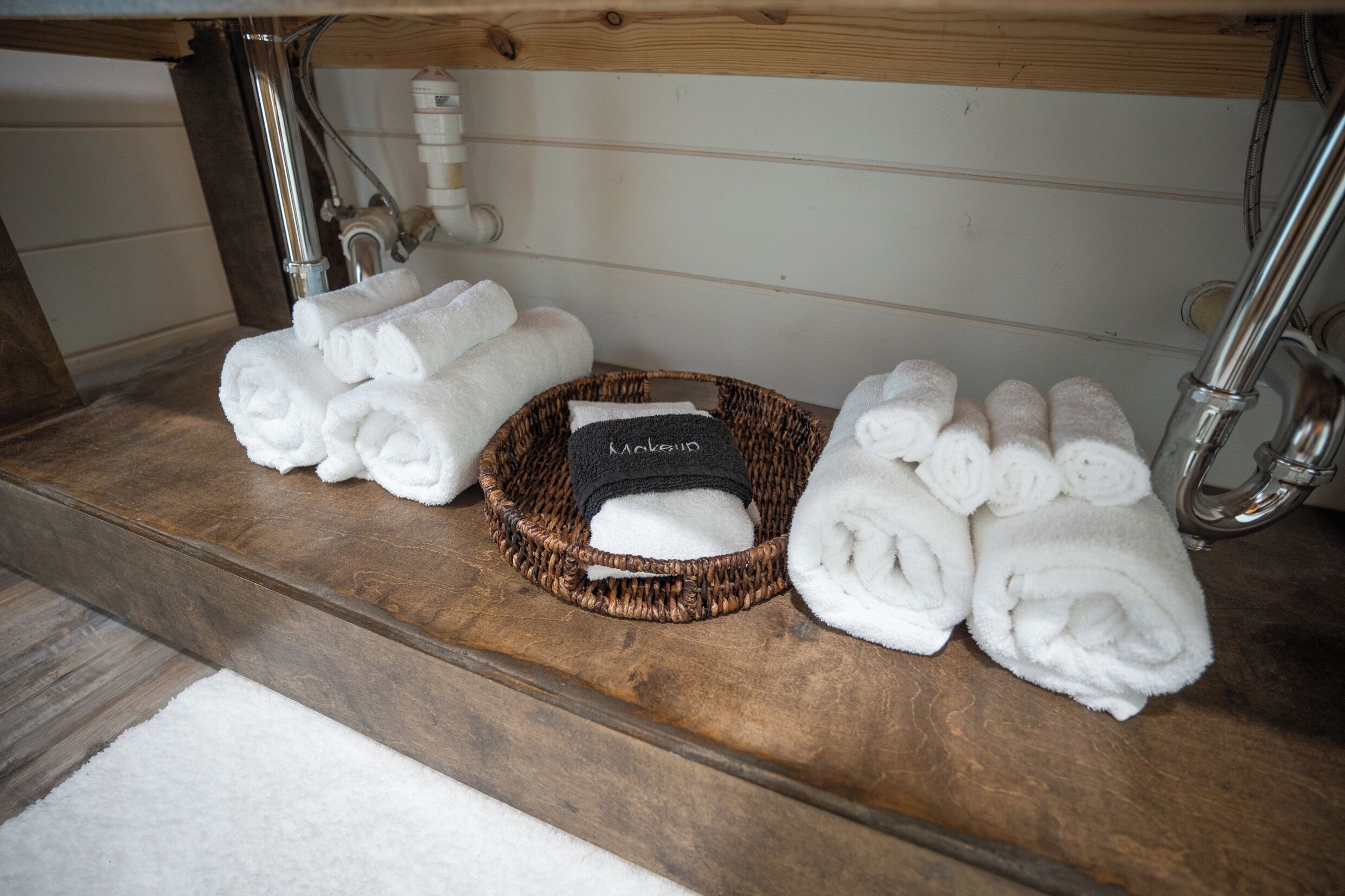 A bathroom with a wooden vanity, a sink, and a towel rack.
