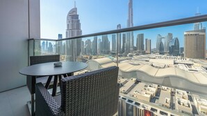 A balcony with a glass railing overlooking a cityscape with prominent skyscrapers. - Luxury Living Spectacular Burj Views (Dubai)
