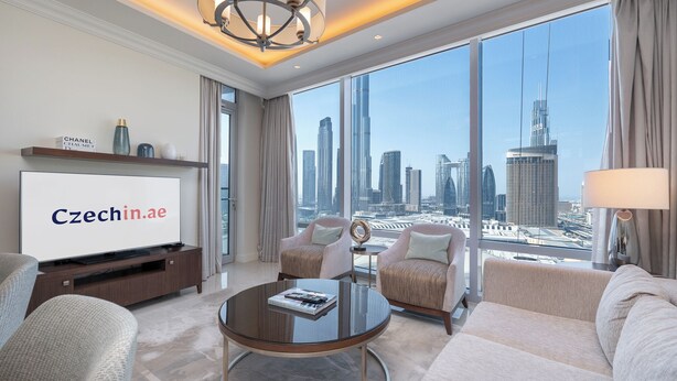 A modern hotel room with a large city view, a flat-screen TV, and comfortable seating. - Luxury Living Spectacular Burj Views (Dubai)