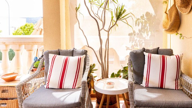 A balcony with wicker chairs, a small round table, and a potted plant. - Villa in Palma de Mallorca  (Palma)