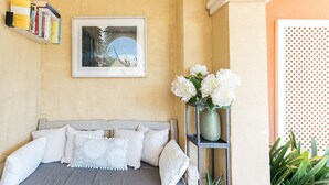 A neatly arranged bedroom with a bed, pillows, a bookshelf, a framed picture, and a vase with flowers. - Villa in Palma de Mallorca  (Palma)