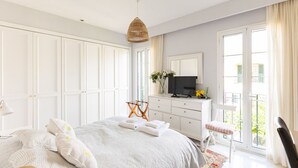 A bedroom with a large bed, a dresser, a television, and a balcony with curtains. - Villa in Palma de Mallorca  (Palma)