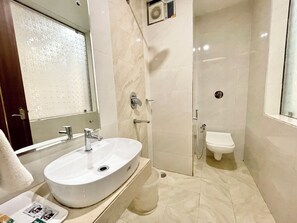 A bathroom with a white sink, a toilet, and a shower.