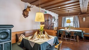 A restaurant interior with wooden beams, a mounted deer head, and a table set for dining.