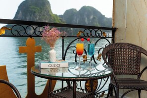 A glass table with a Gucci book, two drinks, and a vase with flowers.