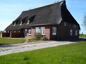 Une grande maison de plain-pied, dotée d’un toit à forte pente, d’une façade en briques et d’un porche à l’avant.