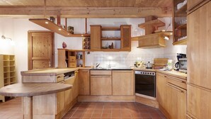 Una cocina con armarios de madera, una isla central, una estufa y un fregadero.
