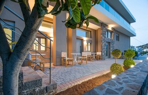 Un edificio moderno con posti a sedere all'aperto, pareti in pietra e un vialetto lastricato.