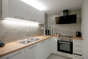Eine moderne Küche mit doppelter Spüle, integriertem Backofen und Mikrowelle.