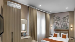 Habitación de hotel con cama, mesita de noche, espejo, armario y aire acondicionado de pared.