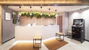 A hotel reception area with a modern design, including a reception desk, a digital kiosk, and a reception counter. - Super Hotel Premier Namba Shinsaibashi Natural Hot Spring (Osaka)