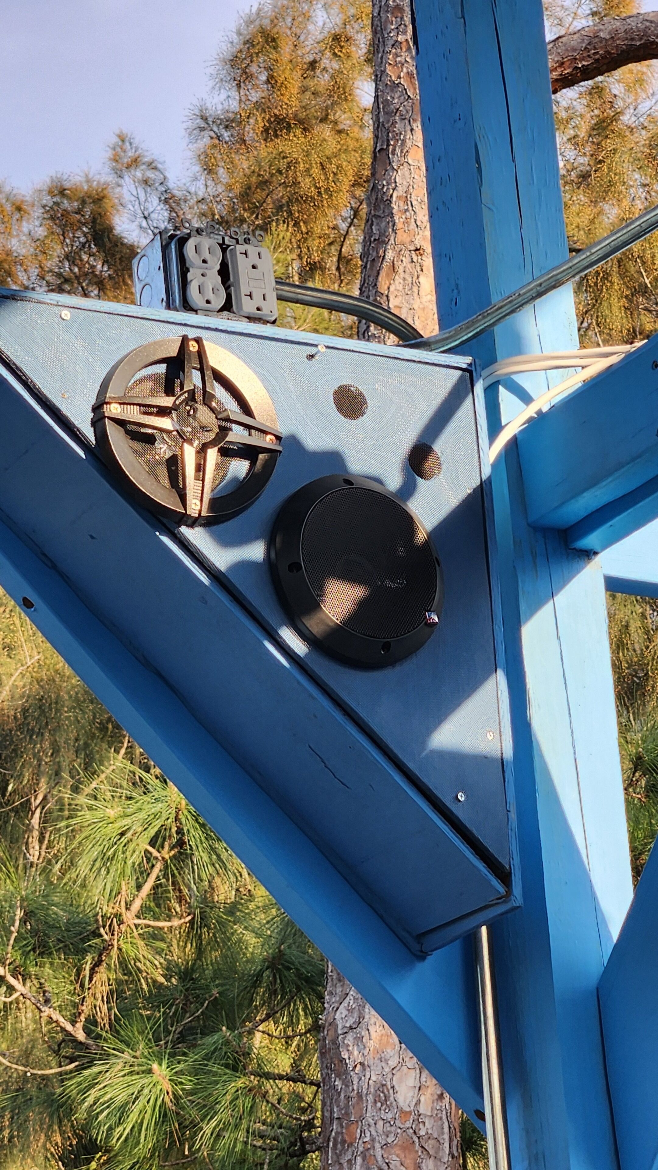 A blue metal structure with two circular vents and a switchboard.