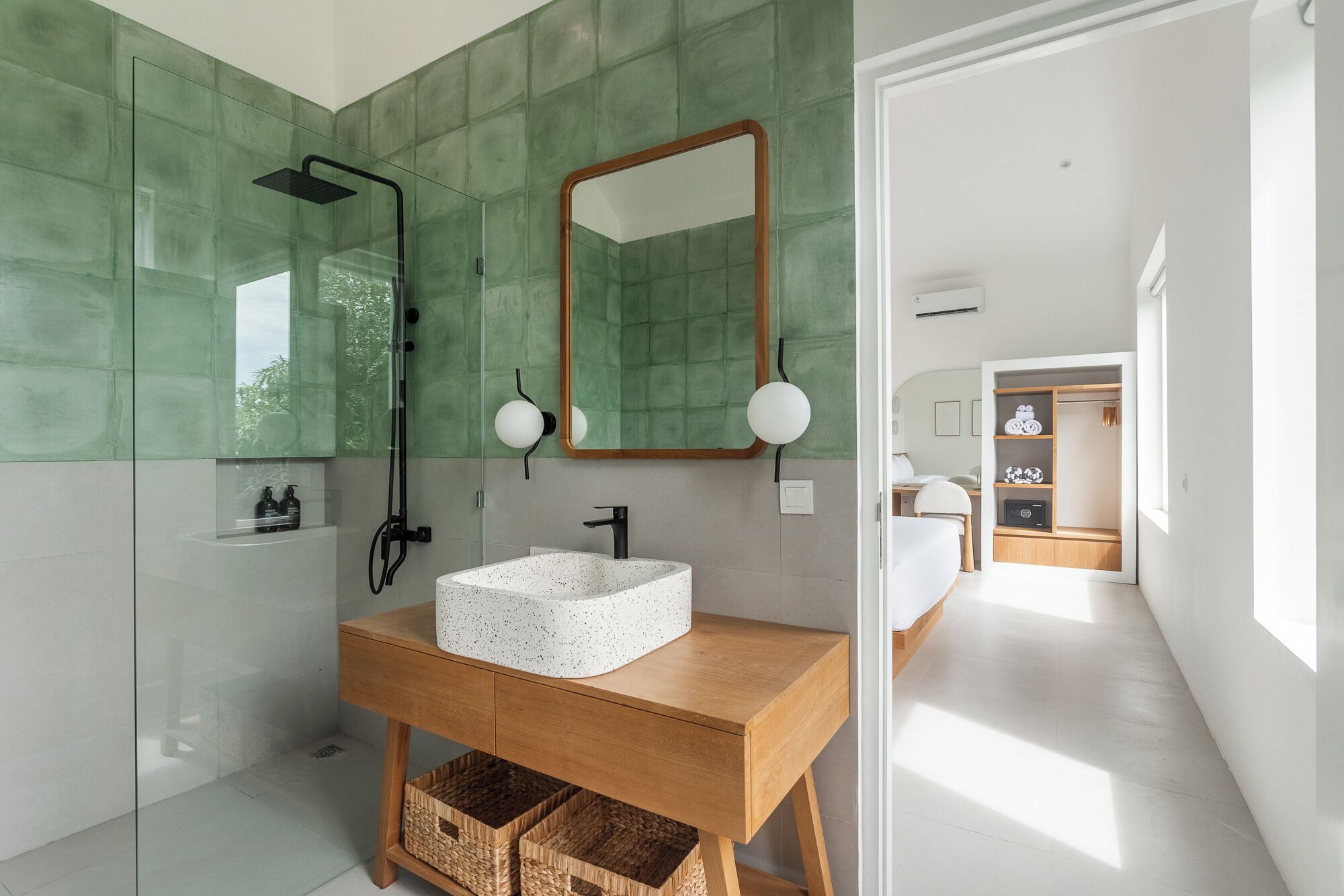 Un bagno moderno con un lavabo freestanding, un box doccia in vetro e uno specchio grande.