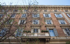 A multi-story building with a classic architectural style, featuring symmetrical windows and decorative moldings. - Deluxe Vatican (Rome)