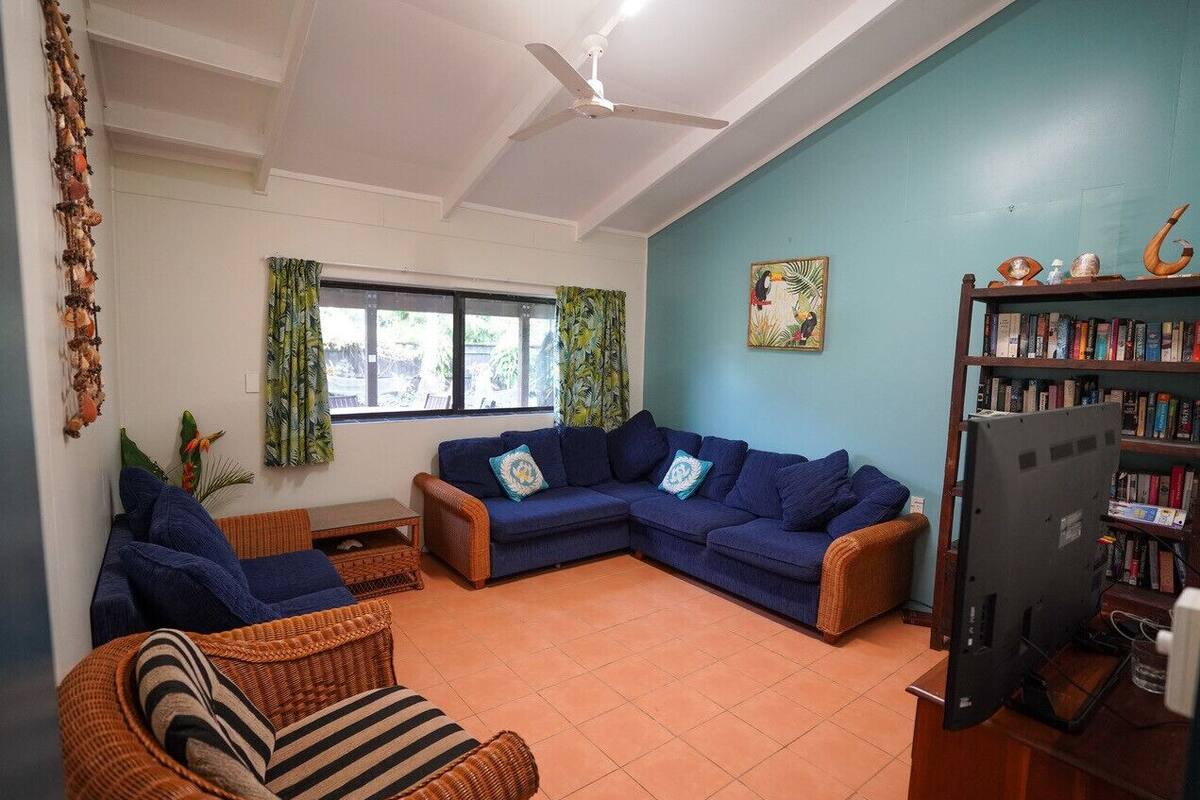 A living room with a sectional sofa, a television, and a bookshelf.