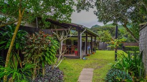 A covered outdoor seating area with a concrete path leading to a building. - Muri Lagoon Lodge (Rarotonga)