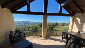 Een balkon met uitzicht op een bergachtig landschap.