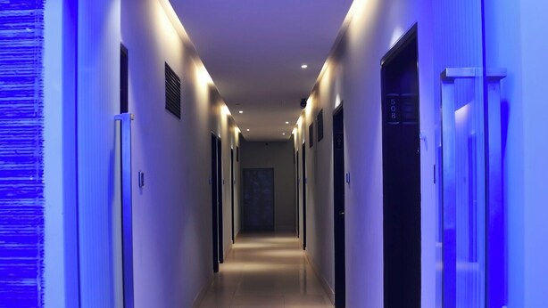 A hotel corridor with a modern design, featuring a long hallway with doors on both sides, recessed lighting, and a tiled floor. - Hotel Grand Royal Dhanmondi  (Dhaka)
