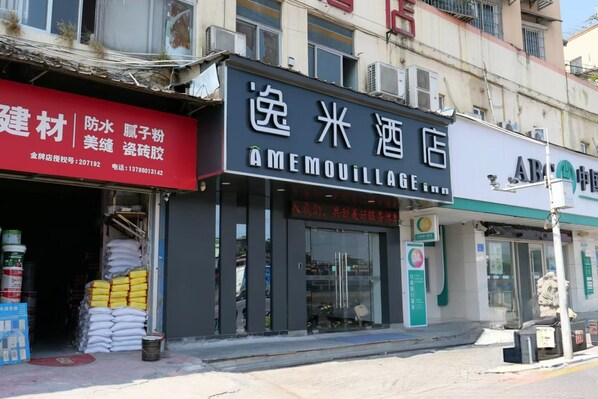 A storefront with a sign for 'AMEMOULAGE' and another sign for 'AIMOUILLAGE'.