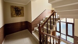 A staircase with wooden railings and a handrail, leading to an upper floor. - Hotel Jafson Accommodates (Srinagar)