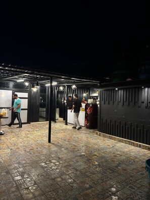 A restaurant with a tiled floor and hanging pendant lights. - Hotel Jafson Accommodates (Srinagar)