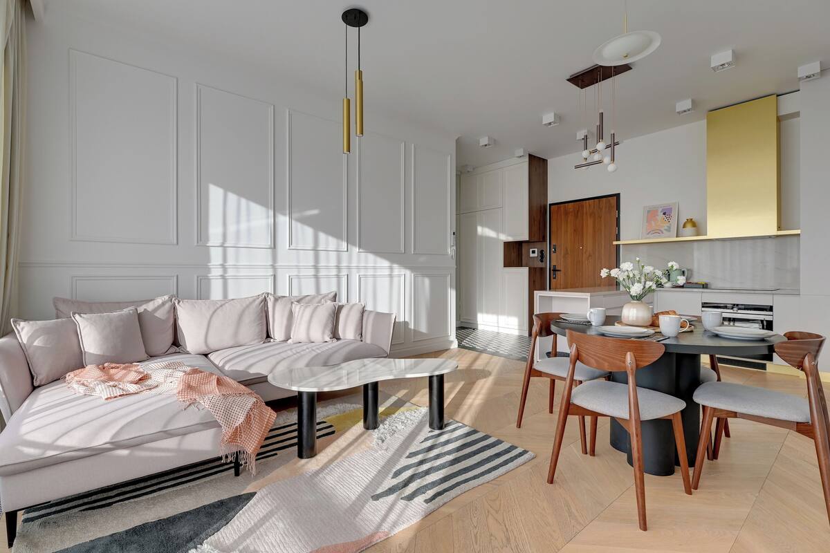 Una sala de estar moderna con sofá, mesa de centro y comedor.