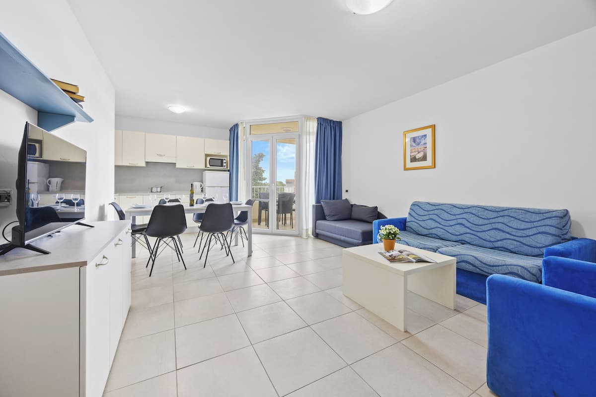 A modern apartment with a kitchen, dining area, and living room.