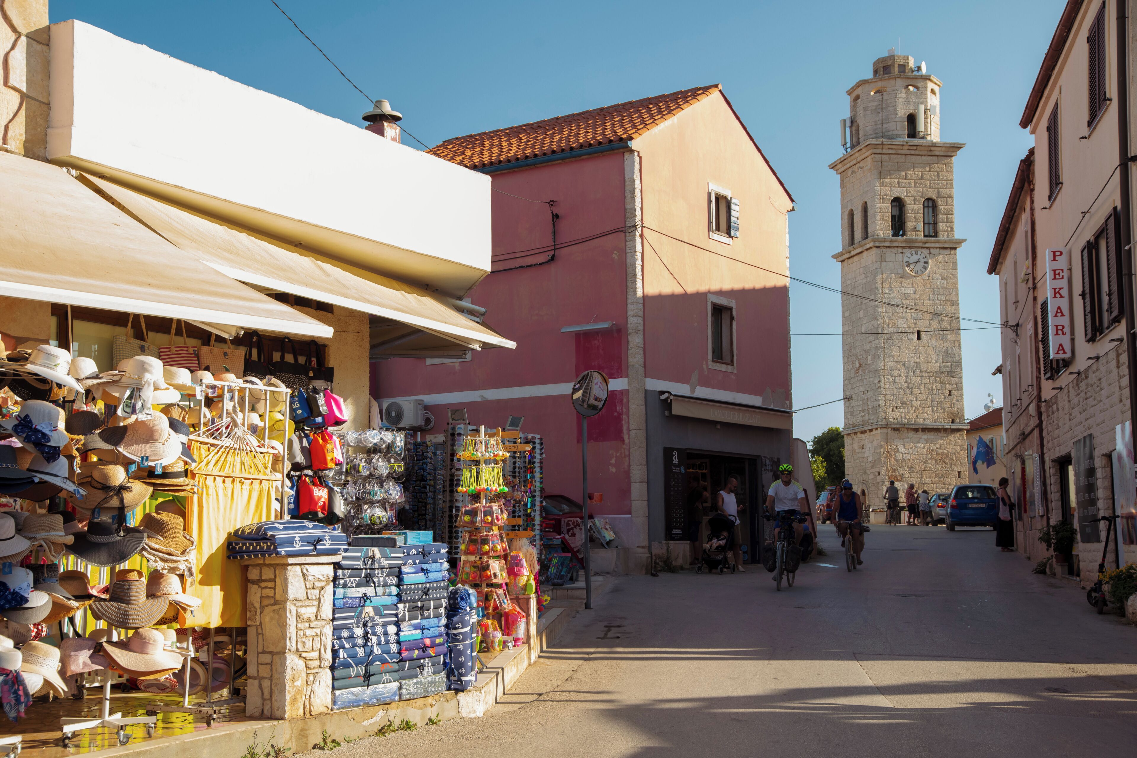 A street with shops, a tower, and a clear sky.