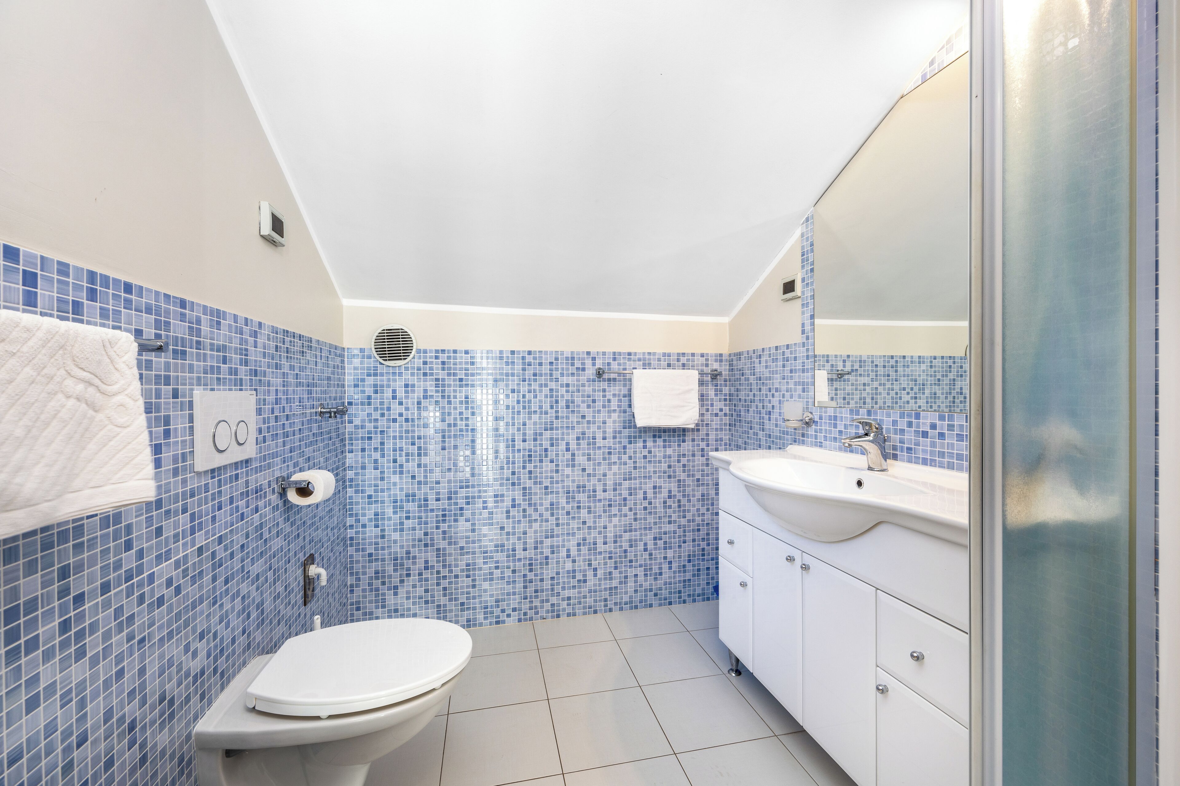 Ein Badezimmer mit Toilette, Waschbecken und Spiegel.
