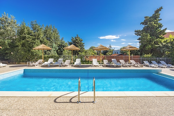 Sesongbasert utendørsbasseng, bassengparasoller og solsenger