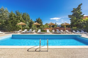 Una piscina al aire libre de temporada, sombrillas