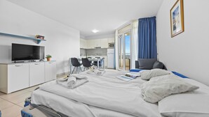 Une chambre d’hôtel moderne équipée d’un lit, d’un bureau, d’une télévision et d’un coin repas.