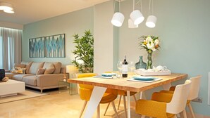 Uma área de jantar moderna com uma mesa de madeira, cadeiras amarelas e um vaso de flores.