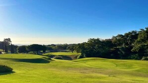 A golf course with well-maintained grass, trees, and a clear sky. - Ojén Apartment Near Golf (Ojen)