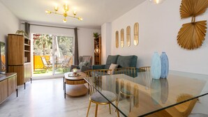A modern living room with a glass dining table, a sofa, and a large window. - Marbella Coastal Comfort (Marbella)