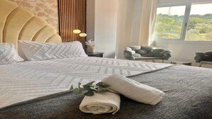 A neatly made bed with a patterned bedspread, a rolled towel, and a decorative plant. - Marbella Coastal Comfort (Marbella)
