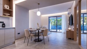 Una cocina moderna con comedor, repisas empotradas con objetos decorativos y un amplio ventanal con vistas al exterior.