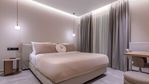 A modern bedroom with a large bed, bedside tables, and a desk. - Phaedrus Living: Athens Luxury Residences Sands (Athina)
