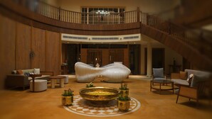 A spacious lobby with a central seating area, a staircase, and a view of the upper floor. - The Solitaire bliss (Tinsukia)