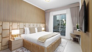 A modern hotel room with a large bed, a desk, and a television. - Exclusive Duplex Villa w Panoramic Terrace Overlooking Burj Khalifa (Dubai)